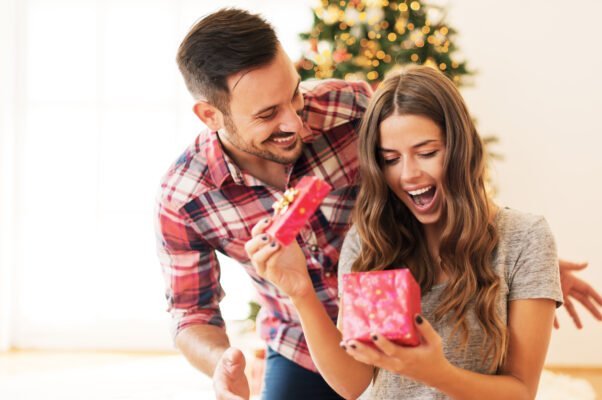Szczęśliwa para - kobieta otwiera prezent